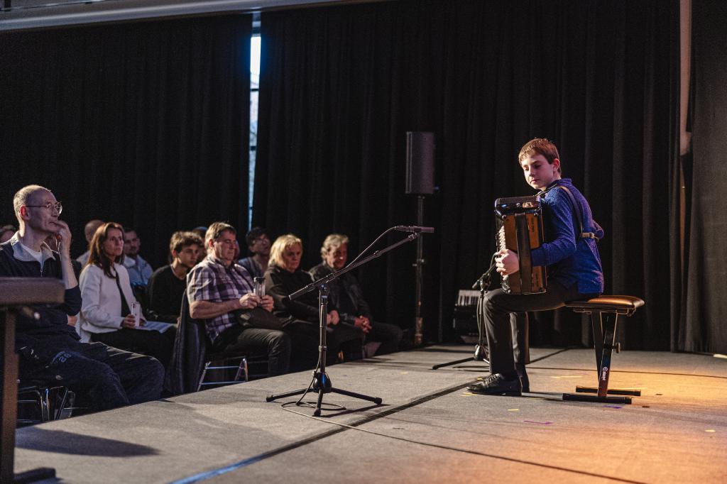 Ein Akkordeonspieler der vor Publikum ein Konzert gibt